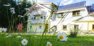 un edificio con un campo di fiori di fronte di Haus Alpengluehn a Iselsberg