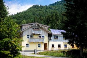 una grande casa bianca con balcone e alberi di Haus Alpengluehn a Iselsberg