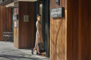une femme en robe marchant dans un couloir dans l'établissement Ohla Eixample, à Barcelone