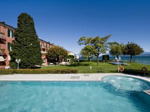 a large swimming pool with the ocean in the background at Hotel Fonte Boiola in Sirmione