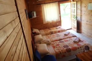 1 dormitorio con 2 camas en una cabaña de madera en Guest House Jadran Pol en Petrovac na Moru