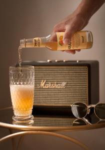 a person is pouring a drink in front of a microwave at ONNO Boutique Hotel & Apartments in Rendsburg