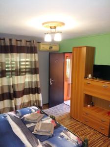 コンスタンツァにあるSea Sideのベッド、テレビ、ドアが備わる客室です。
