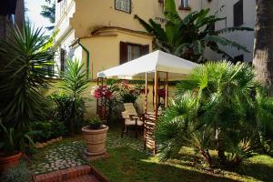 un jardín con una sombrilla blanca frente a un edificio en Green Hotel, en Roma