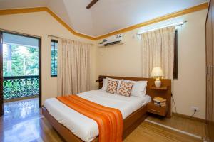 um quarto com uma cama e uma grande janela em Mistral Holidays em Benaulim