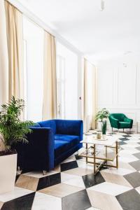Готель Континент Миколаїв في نيكولايف: غرفة معيشة مع أريكة زرقاء وأرضية متقلصة