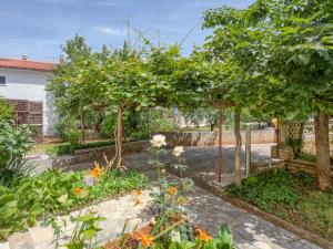 un jardin avec des arbres et des fleurs dans l'établissement Apartment Daria-1 by Interhome, à Poreč