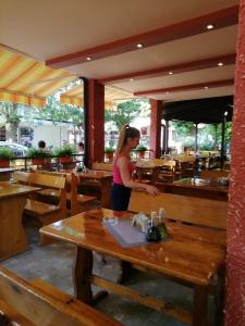 a woman standing at a table in a restaurant at Guest House Nedelchevi in Primorsko