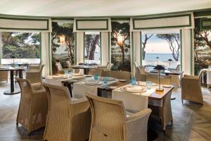 a dining room with tables and chairs and windows at Mezzatorre Hotel & Thermal Spa in Forio d'Ischia