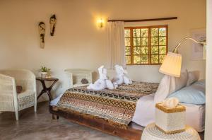 a bedroom with two stuffed animals sitting on a bed at Mbizi Bush Lodge in Grietjie Nature Reserve +147 photos