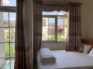 een slaapkamer met een bed en een raam met uitzicht bij Khách sạn Hoàng Trang in Cao Bằng