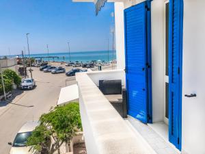 トッレ・モッツァにあるHotel I Colori Del Mareの駐車場の景色を望むバルコニーに面した青いドア