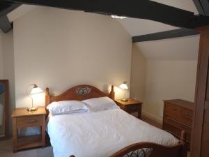 a bedroom with a bed with two night stands and two lamps at Castle Square Apartments Beaumaris in Beaumaris