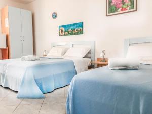 トッレ・モッツァにあるHotel I Colori Del Mareのベッド2台が隣同士に設置された部屋です。