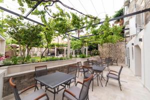 eine Reihe von Tischen und Stühlen auf einer Terrasse in der Unterkunft Apartments Trifunovic Old Town in Budva