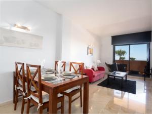マニルバにある2055-Superb 2bedrooms apt, Gibraltar and sea viewのリビングルーム(ダイニングテーブル、赤いソファ付)