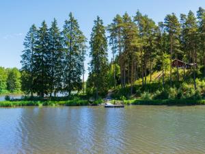 un bateau sur un lac avec des arbres en arrière-plan dans l'établissement Holiday Home Kivitasku by Interhome, à Hirsjärvi