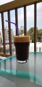 a drink sitting on a glass table in front of a window at NEX Hostel in Nicosia