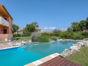 a swimming pool with blue water in a yard at Holiday Home Mario 1 by Interhome in Hreljići