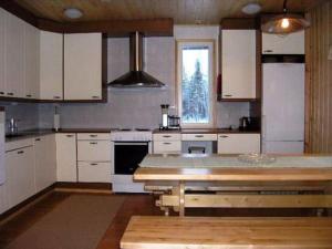 a kitchen with white cabinets and a table in it at Holiday Home Kurrela by Interhome in Toiviaiskylä