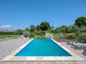a swimming pool in a yard with two chairs at Holiday Home Mario 1 by Interhome in Hreljići