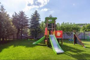 a playground with a slide in the grass at Dom Gościnny Lider in Niechorze