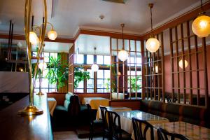a restaurant with tables and chairs and windows at Hotel Continental Gare du Midi in Brussels