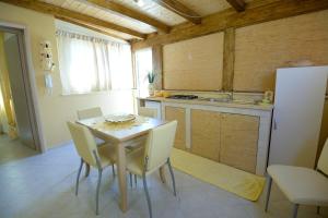 a kitchen with a table and chairs and a refrigerator at Case Vacanza Edera in Trapani
