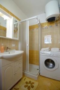 a bathroom with a washing machine and a sink at Case Vacanza Edera in Trapani