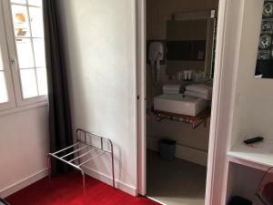 a bathroom with a sink and a mirror at Hotel Reine Mathilde in Bayeux