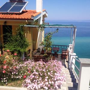 a house with a balcony with a view of the ocean at Aegean Colors in Skala Marion