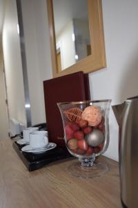 a glass vase filled with fruit and cookies on a table at PremierLux Serviced Apartments in Ilford