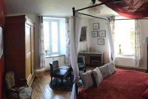 1 dormitorio con 1 cama, escritorio y ventanas en Gîte "L'échappée amoureuse et féérique", en Paliseul