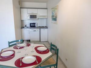 - une table à manger avec des assiettes rouges et des verres à vin dans l'établissement Apartment L'Open-10 by Interhome, à Fréjus