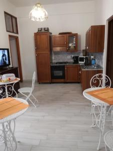 a kitchen with wooden cabinets and tables and chairs at Zia Amalia Villa Asfodelo in Alghero