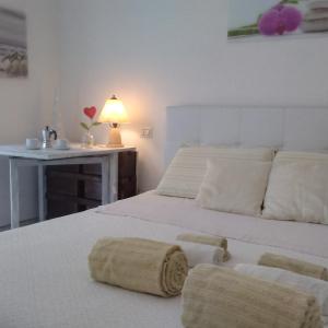 een slaapkamer met een bed met 2 kussens en een tafel bij Casa Valentina in San Benedetto del Tronto