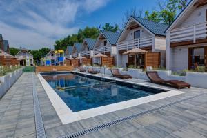 a swimming pool in the backyard of a house at Natural Resort in Gąski