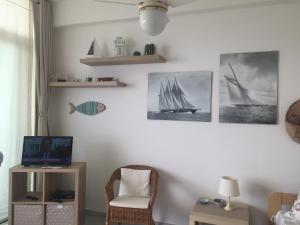ein Wohnzimmer mit einem TV und einigen Bildern von Segelbooten in der Unterkunft Apartment Sillemi - Casa Sille in Letojanni
