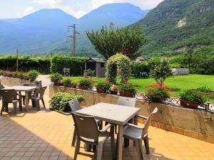 a patio with tables and chairs with mountains in the background at Agritur Ca' Scudiera in Belluno Veronese