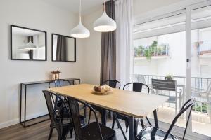 a dining room with a wooden table and chairs at Sitges Group Calm Beach in Sitges