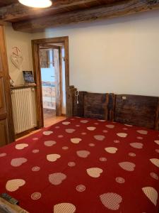 a bedroom with a bed with a red rug with white hearts at La Tzambretta in Aosta