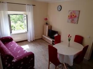 uma sala de estar com uma mesa e um sofá em Apartment Luka em Mali Lošinj