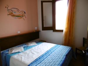 1 dormitorio con cama con espejo y ventana en Casa Mare, en Balestrate