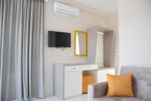 a living room with a tv and a chair at Summer Gate Hotel in Ksamil +37 photos