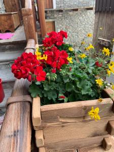 a wooden box filled with red and yellow flowers at La Tzambretta in Aosta