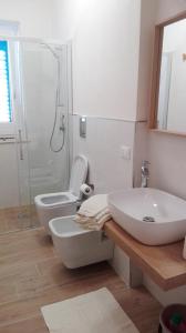 y baño con aseo, lavabo y ducha. en Il Viaggiatore, en Marettimo