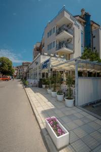 a street with white pots of flowers in front of a building at Hotel Briz in Sozopol