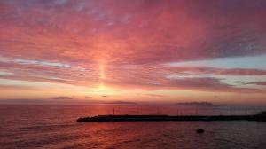 un tramonto sull'oceano con un molo in acqua di Il Viaggiatore a Marettimo