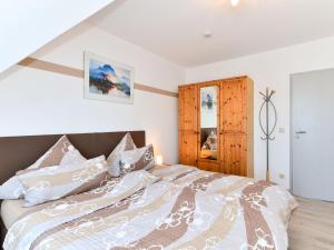 a bedroom with a bed and a wooden cabinet at Ferienwohnungen Meyer in Hochbuch