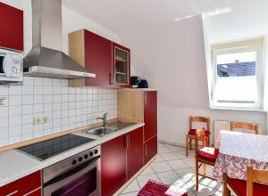 a kitchen with red cabinets and a sink at Ferienwohnungen Meyer in Hochbuch